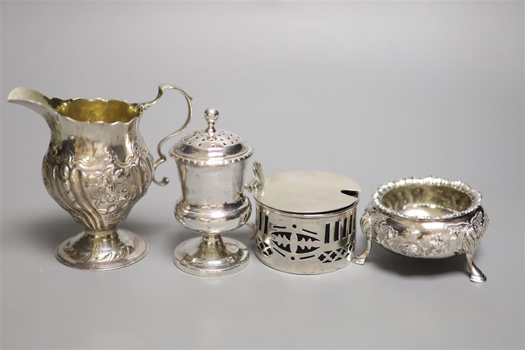 A collection of small silver items, comprising a George III helmet-shaped embossed cream jug,